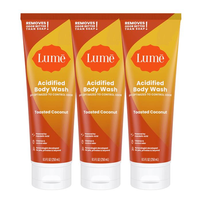 Three orange tubes of body wash in the scent Toasted Coconut